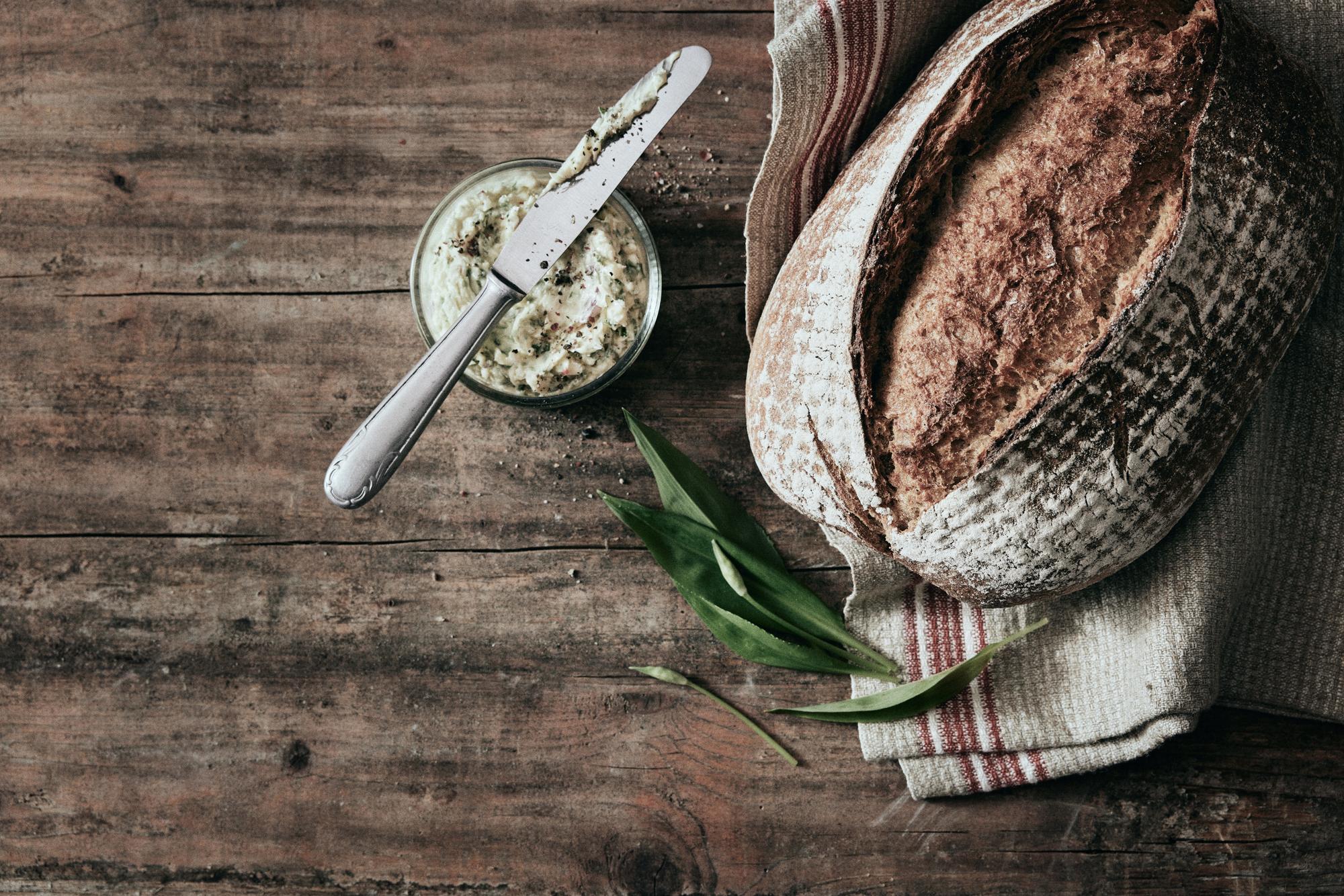 Close-up of artisanal bread and fresh herbs on table
